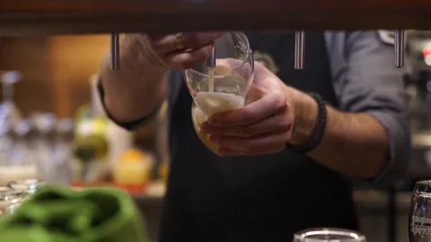 Bartender close up foam rising as beer is poured into glass Filmed on high .. Stock Footage 265767567