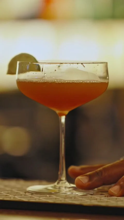 The bartender decorates an alcoholic drink with a slice of lime Stock Footage 329547610