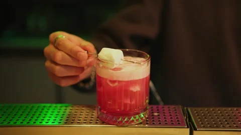 The bartender decorates the finished drink before giving it away Stock Footage 309952247