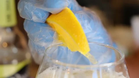 Bartender decorates a ready-made alcoholic cocktail in glass with orange slice Stock Footage 160649969