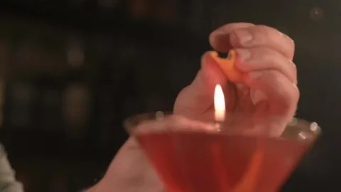 Bartender decorates a red cocktail with orange peel. cocktail in an elegant Stock Footage 152833373
