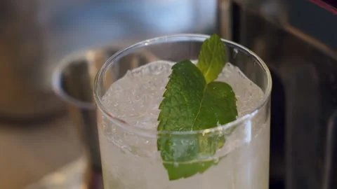 Bartender in disposable glove puts mint in a glass with a mahito filled with ice Stock Footage 160649583