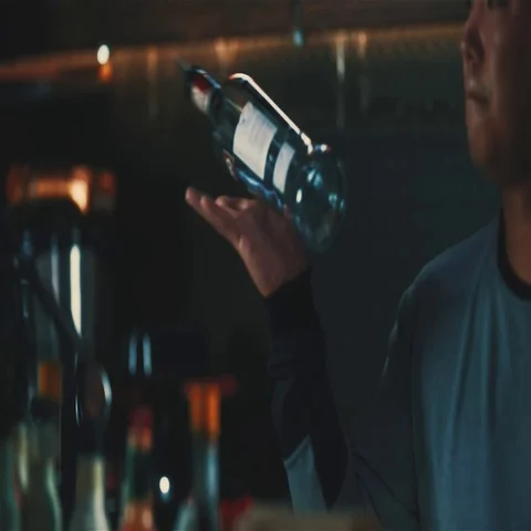 Bartender doing tricks bottle spin bar HD slow motion video. Barman  counter Stock Footage 69377453