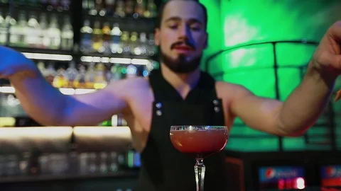 The bartender draws up the finished cocktail and serves on the camera. Stock Footage 103372230