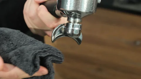 Bartender dries metal holder of coffee machine with towel Video stock 306624176