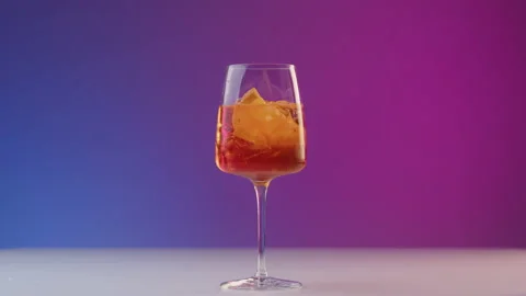 Bartender drops a slice of orange into glass with cold summer cocktail with a Stock Footage 239434143