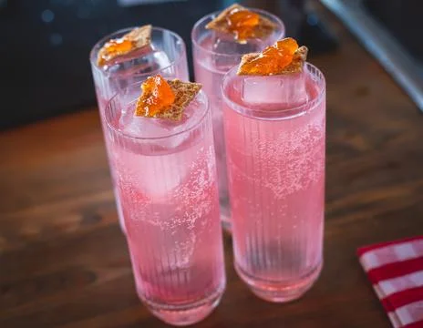 Bartender in front of beautiful row of different coloured alcohol cocktails o Stock Photos