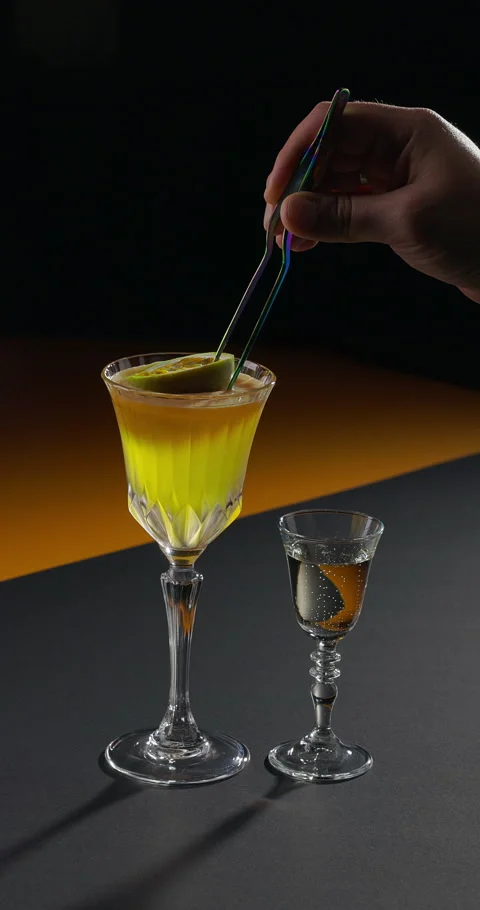 Bartender garnishing cocktail with passion fruit. Two step cocktail - glass of Stock Footage 311691589