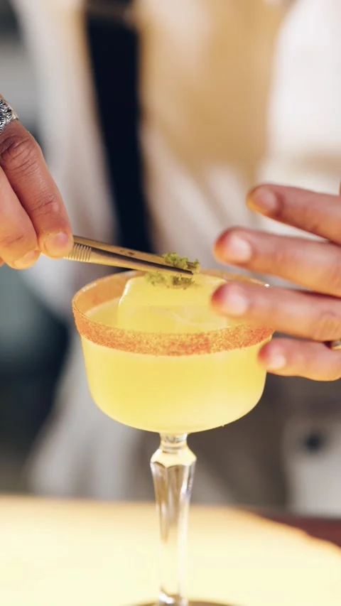 Bartender garnishing yellow cocktail with lime zest Stock Footage 331223211