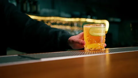 The bartender gives the customer a delicious gin garden alcoholic cocktail with Video stock 240440878