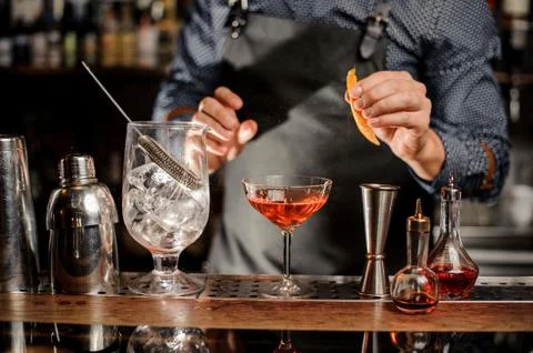 Bartender is going to spray an orange peel in cocktail glass Fotos Stock