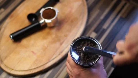 Bartender grinds coffee beans on a manual coffee grinder by turning the handle Stock Footage 266862570