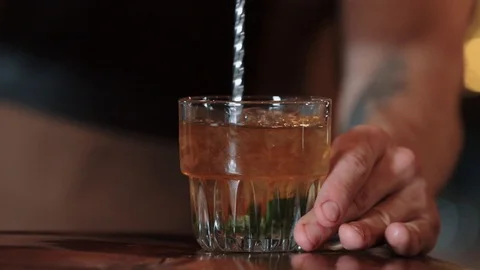The bartender grinds a spoonful of cocktail with ice, fresh, cold, alcohol. Mint Stock Footage 129110697