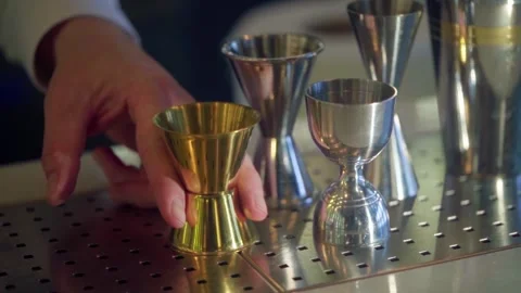 Bartender hand picking up gold jigger from stainless steel professional equ.. Stock Footage 337406916