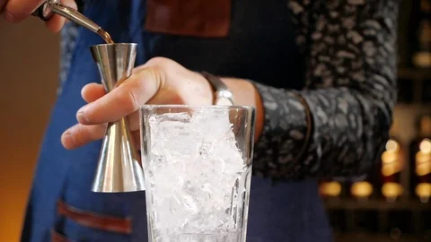 Bartender hands pouring cocktail ingredient in jigger - slow motion Stock Footage 105295387