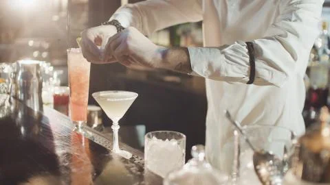 Bartender in hat is preparing cocktail in bar Stock Photos