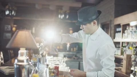 Bartender in hat is preparing cocktail in bar Stock Photos