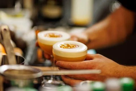 Bartender holding two passion fruit cocktails Stock Photos