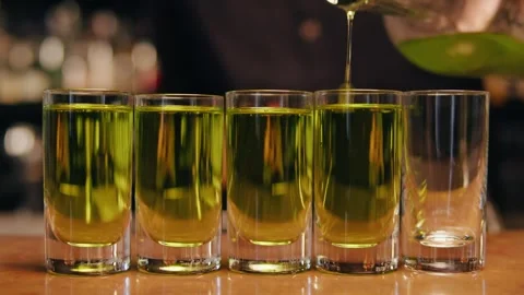 Bartender made some alcohol shots for guests close-up. Night bar with many Stock Footage 253577188