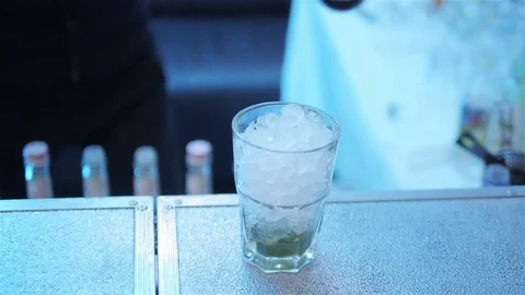 Bartender makes alcohol cocktail pour syrup into ice glass close up slow motion Stock Footage 70132855
