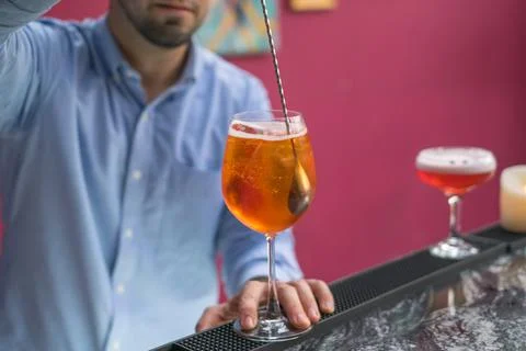 The bartender makes Aperol spritz summer cocktail in mister glass. Stock-Fotos