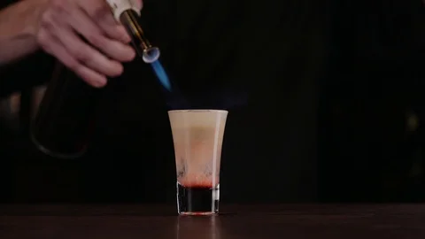 The bartender makes a cocktail of fire. Hiroshima cocktail. The barman ignites Stock Footage 97826079
