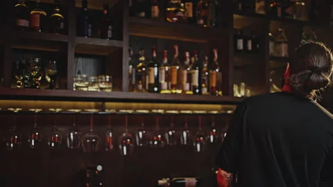 Bartender makes order on phone for missing drinks in bar Stock Footage 196290858