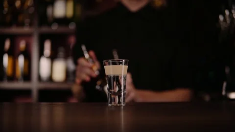 Bartender making alcohol coctail in restaurant. Expert barman is adding Stock Footage 97825329