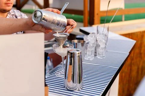 Bartender making and decorating orange cocktail close-up Stock Photos