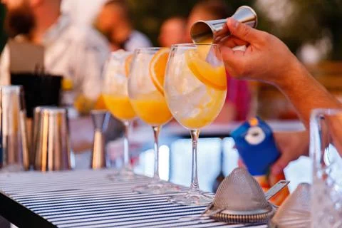 Bartender making and decorating orange cocktail close-up Stock Photos