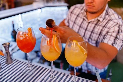 Bartender making and decorating orange cocktail close-up Stock Photos