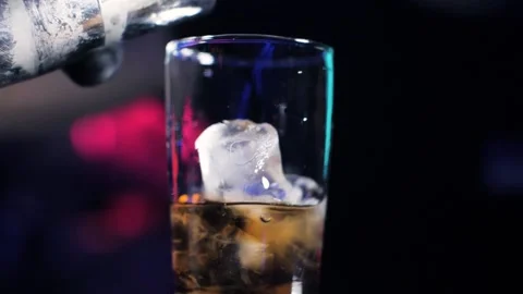 Bartender making cocktail, pouring drink into transparent glass with ice cubes Stock Footage 141109679
