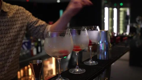 A bartender making a cocktail, throwing berry into glass. Stock Footage 244964002
