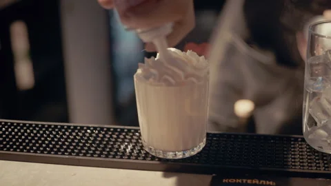 Bartender making delicious alcoholic cocktail with whipped cream Video stock 319772202