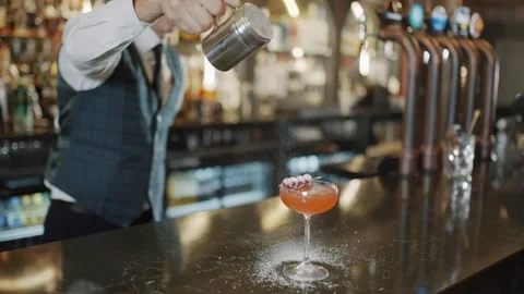 A bartender is making a drink with a garnish on top of a glass Stock Footage 295996301