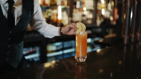 A bartender is making a drink with a lime Stock Footage 295996128