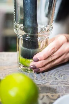 Bartender making refreshing coctail on a bar background. Dark moody style. Ic Stock Photos