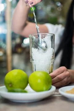 Bartender making refreshing coctail on a bar background. Dark moody style. Ic Stock Photos