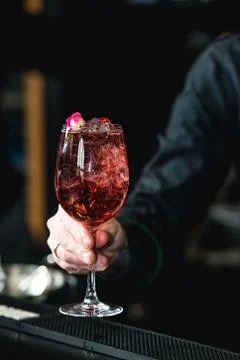 Bartender making refreshing pink coctail with a rose on top isolated on a b.. Stock Photos