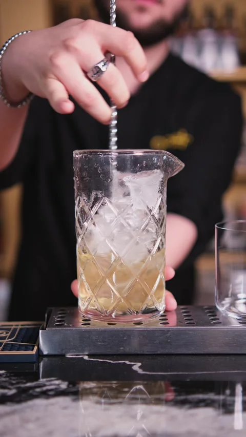 The bartender mixes the cotail in a glass Stock Footage 310694588