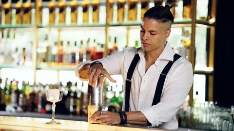 Bartender mixing cocktail using shaker at bar Stock Photos