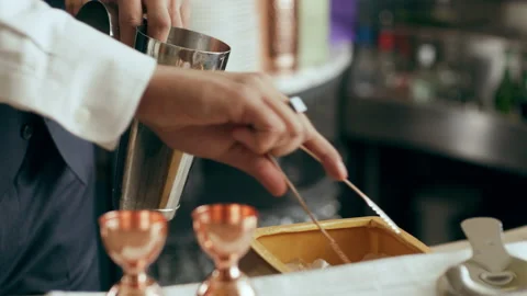 Bartender mixologist adding ice into shaker making classic Daiquiri cocktail in Stock Footage 199453009