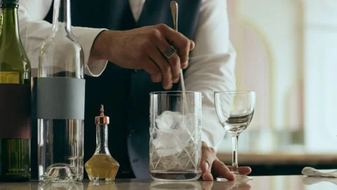 Bartender mixologist combining ingredients, stirring and making a Martini cockta Stock Footage 199459046