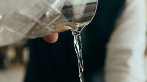 Bartender mixologist making, garnishing and pouring a Martini cocktail in a beau Stock Footage 199457267