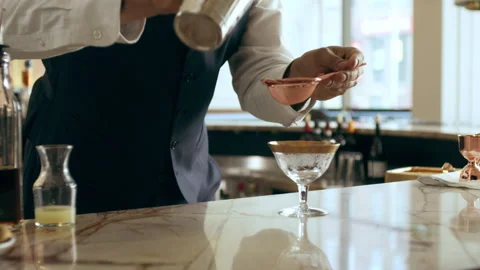 Bartender mixologist pouring cocktail using strainer to make classic Daiquiri co Stock Footage 199460699