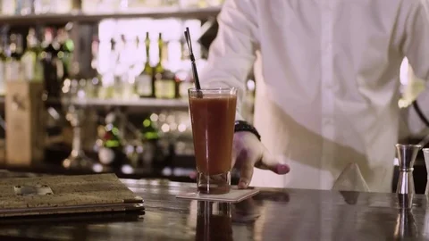 The bartender moves the finished cocktail to the edge of the bar counter close Stock Footage 76720471