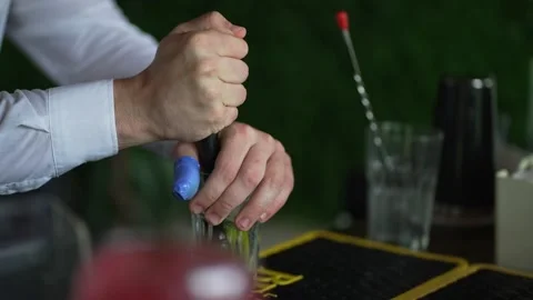 Bartender muddling ingredients in glass at bar counter Stock Footage 331049225