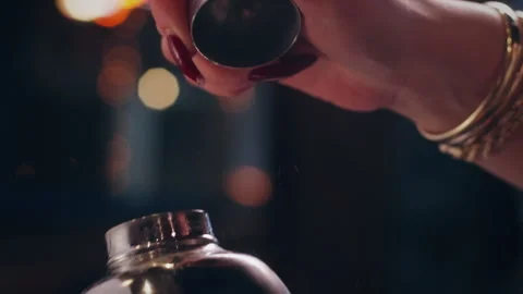 Bartender Opening Cocktail Shaker with Both Hands at Lively Night Bar Stock Footage 328973703