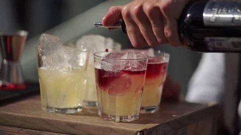 Bartender in an outdoor bar pours a cocktail into a glasses. Stock Footage