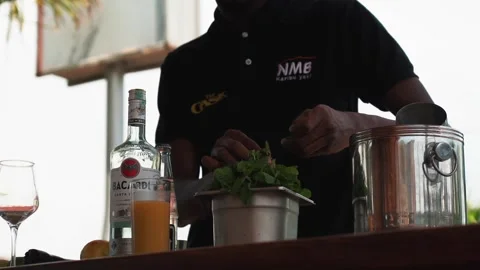 Bartender picking mint leaves to make a passion fruit mojito cocktail Stock Footage 230080373